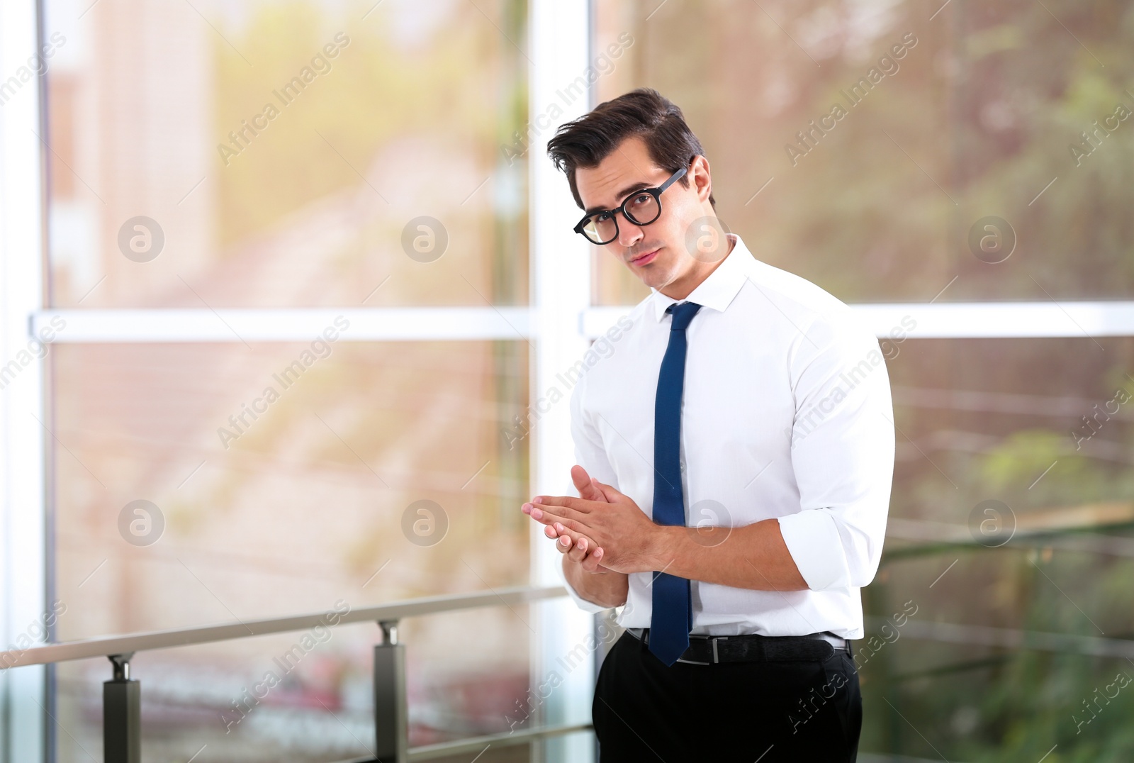 Photo of Handsome young man in stylish clothes with glasses indoors