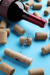 Photo of Corkscrew with wine bottle and stoppers on turquoise background