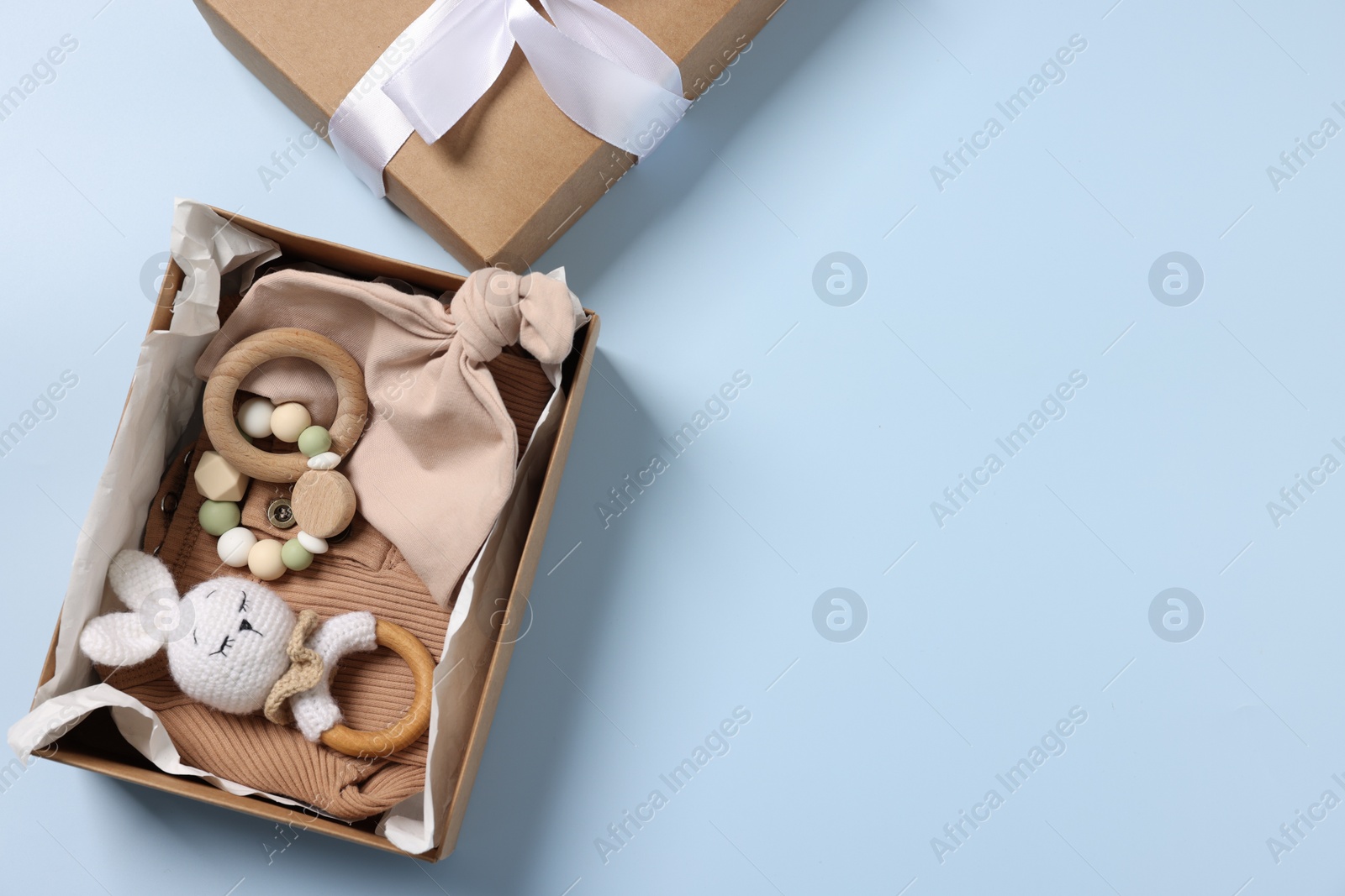 Photo of Different baby accessories in box on light blue background, top view. Space for text