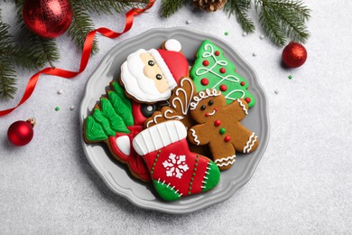 Tasty homemade Christmas cookies and decor on light grey table, flat lay