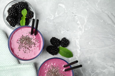 Flat lay composition with glasses of delicious blackberry smoothie on marble background. Space for text