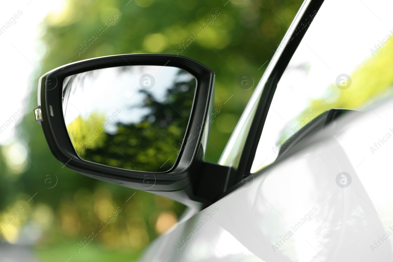 Photo of Side view mirror of modern car on blurred background, closeup