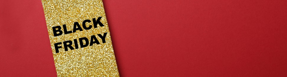 Image of Golden tag with words Black Friday on red background, top view with space for text. Banner design