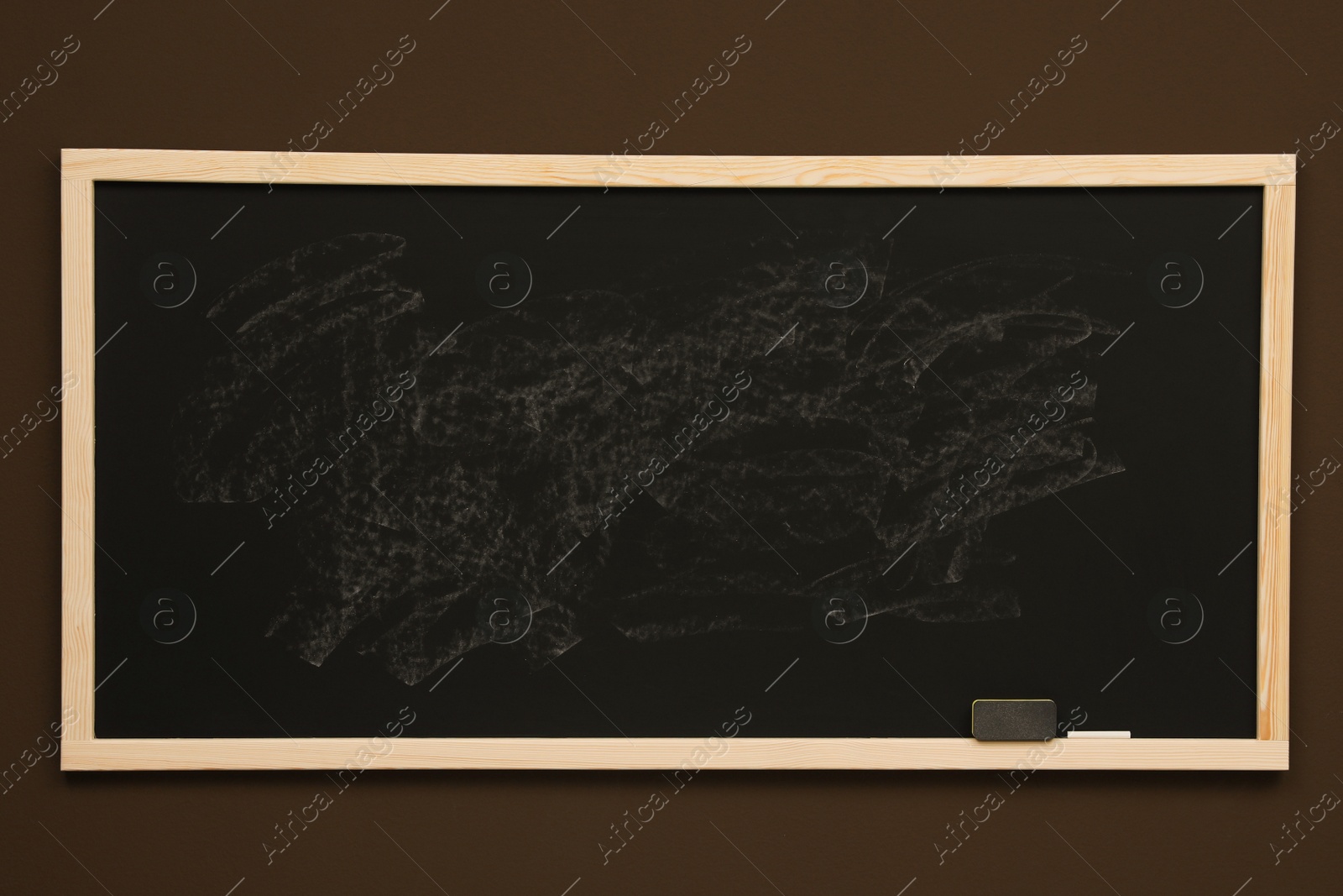 Photo of Dirty black chalkboard hanging on brown wall