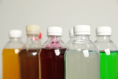 Photo of Bottles of soft drinks on grey background, closeup