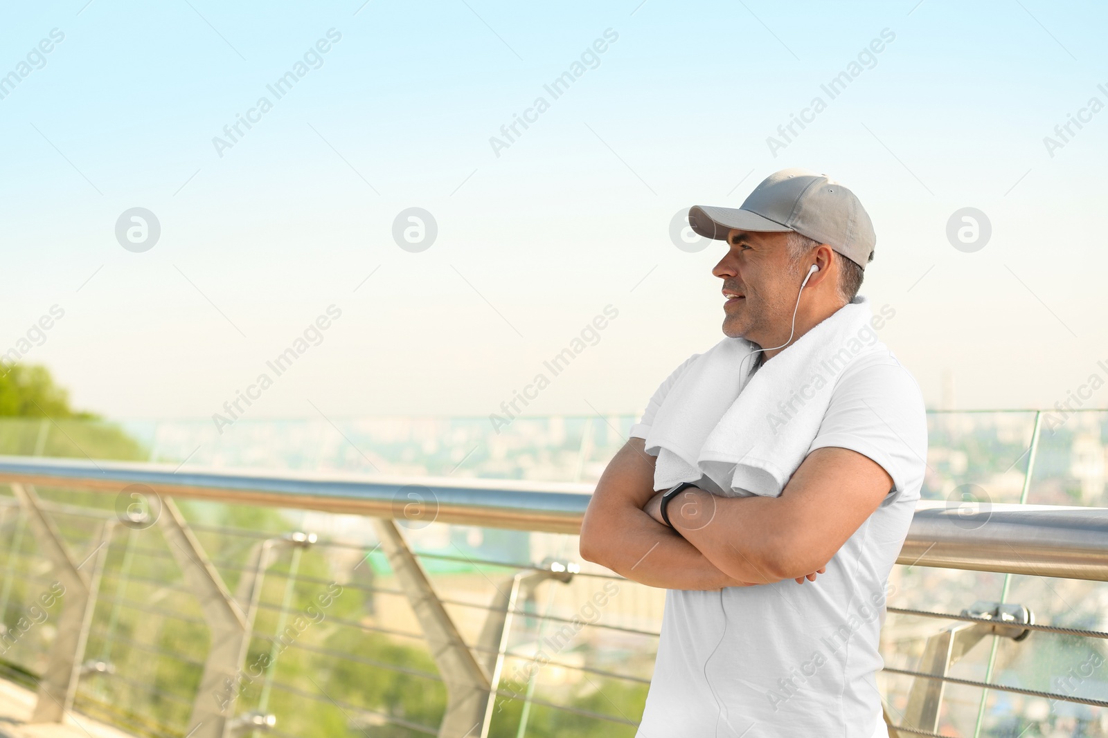 Photo of Handsome mature man in sportswear on bridge, space for text. Healthy lifestyle