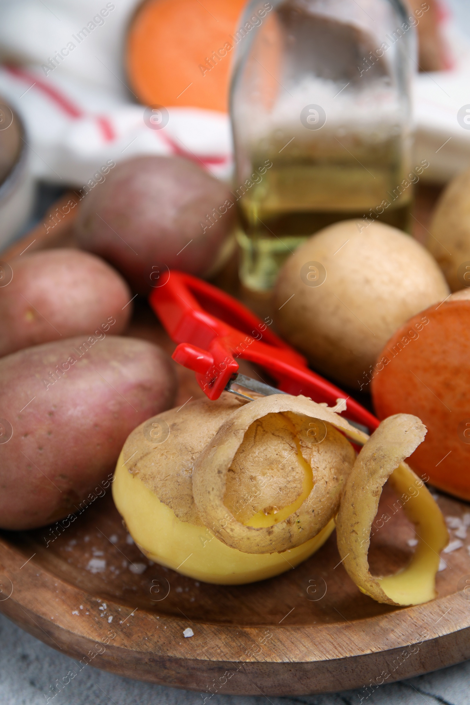 Photo of Different types of fresh potatoes wooden board, closeup