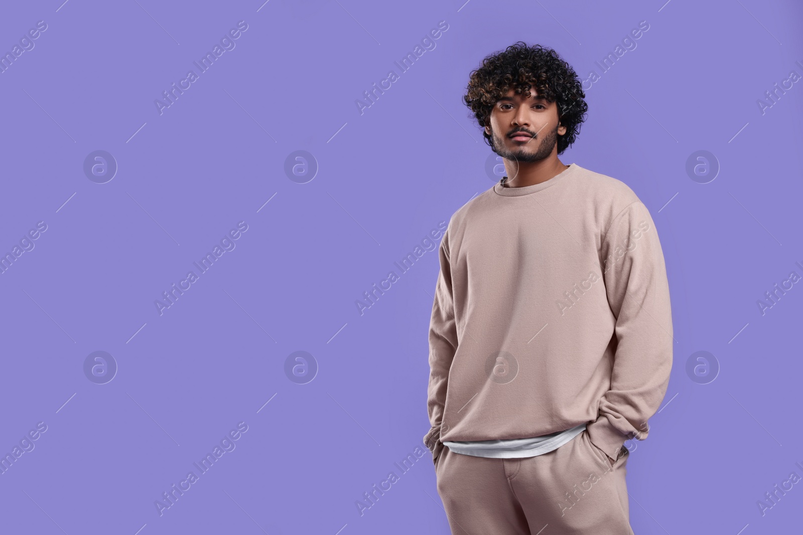 Photo of Handsome young man on violet background, space for text