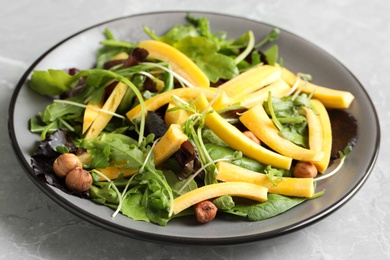 Photo of Delicious fresh carrot salad served on grey marble table, closeup