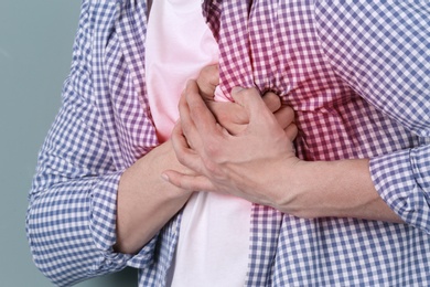 Photo of Young man having heart attack, closeup