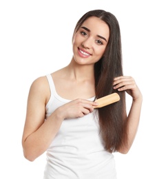 Photo of Beautiful smiling young woman with hair brush on white background