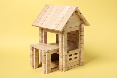 Wooden building on yellow background. Children's toy