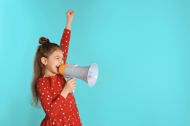 Photo of Cute funny girl with megaphone on color background. Space for text