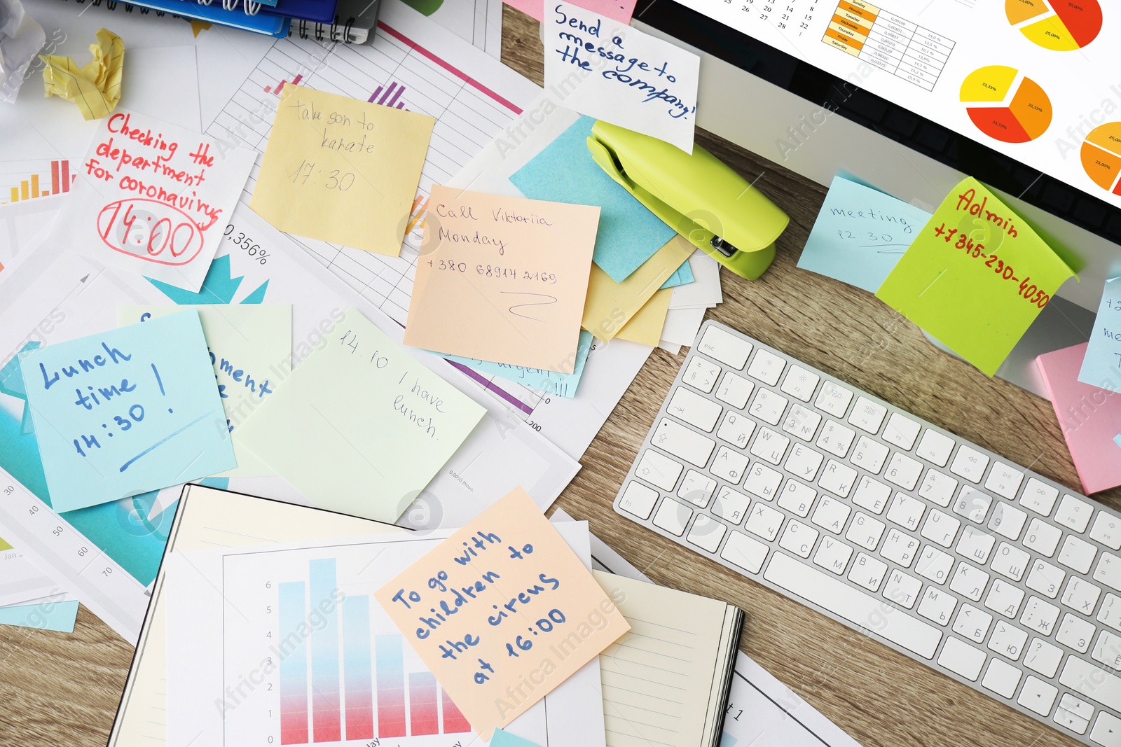 Photo of Computer, notes and office stationery in mess on desk, top view. Overwhelmed with work