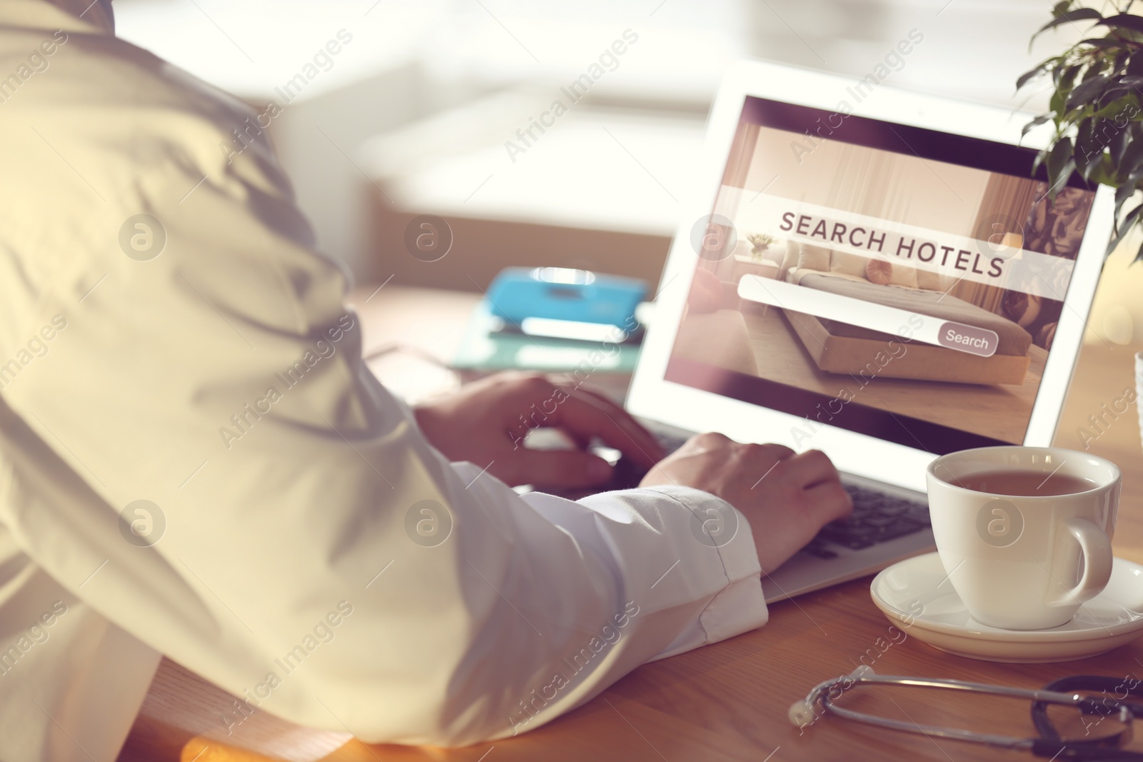 Image of Doctor searching hotel using laptop at table, closeup. Booking online service