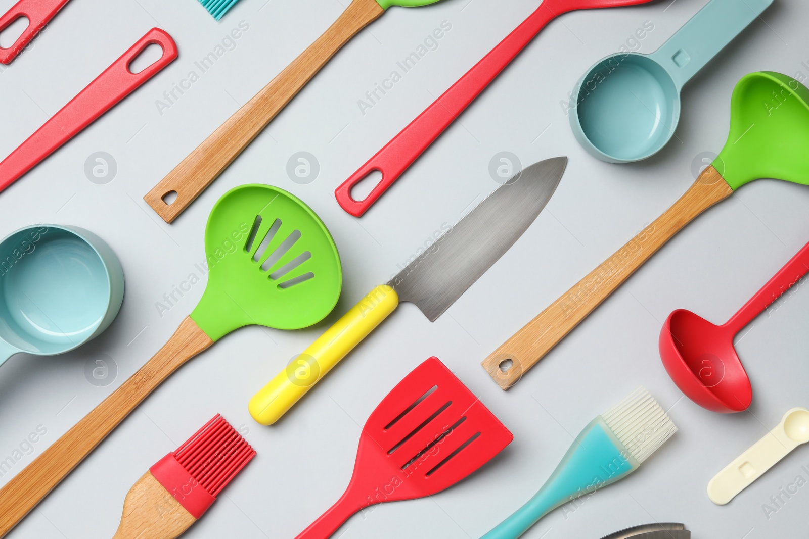 Photo of Set of modern cooking utensils on light background, flat lay