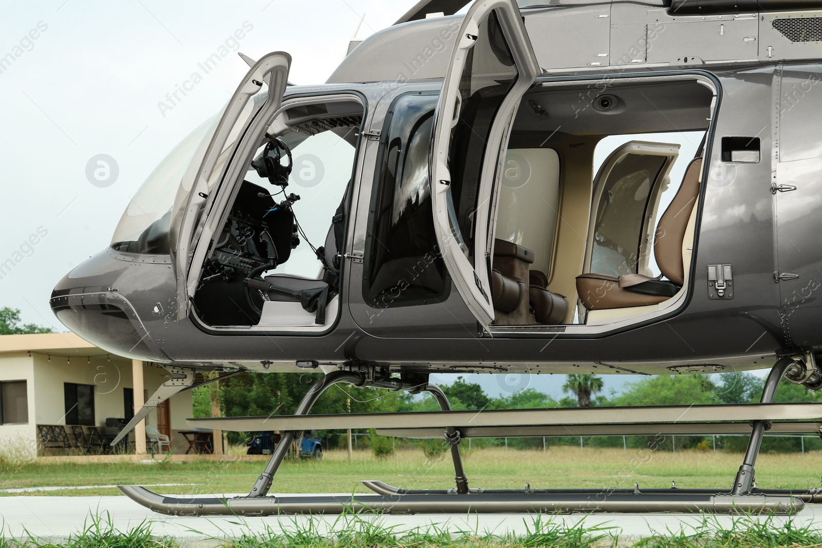 Photo of New helicopter with open cabin doors on helipad outdoors