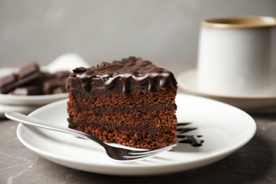 Photo of Tasty chocolate cake served on grey table, closeup