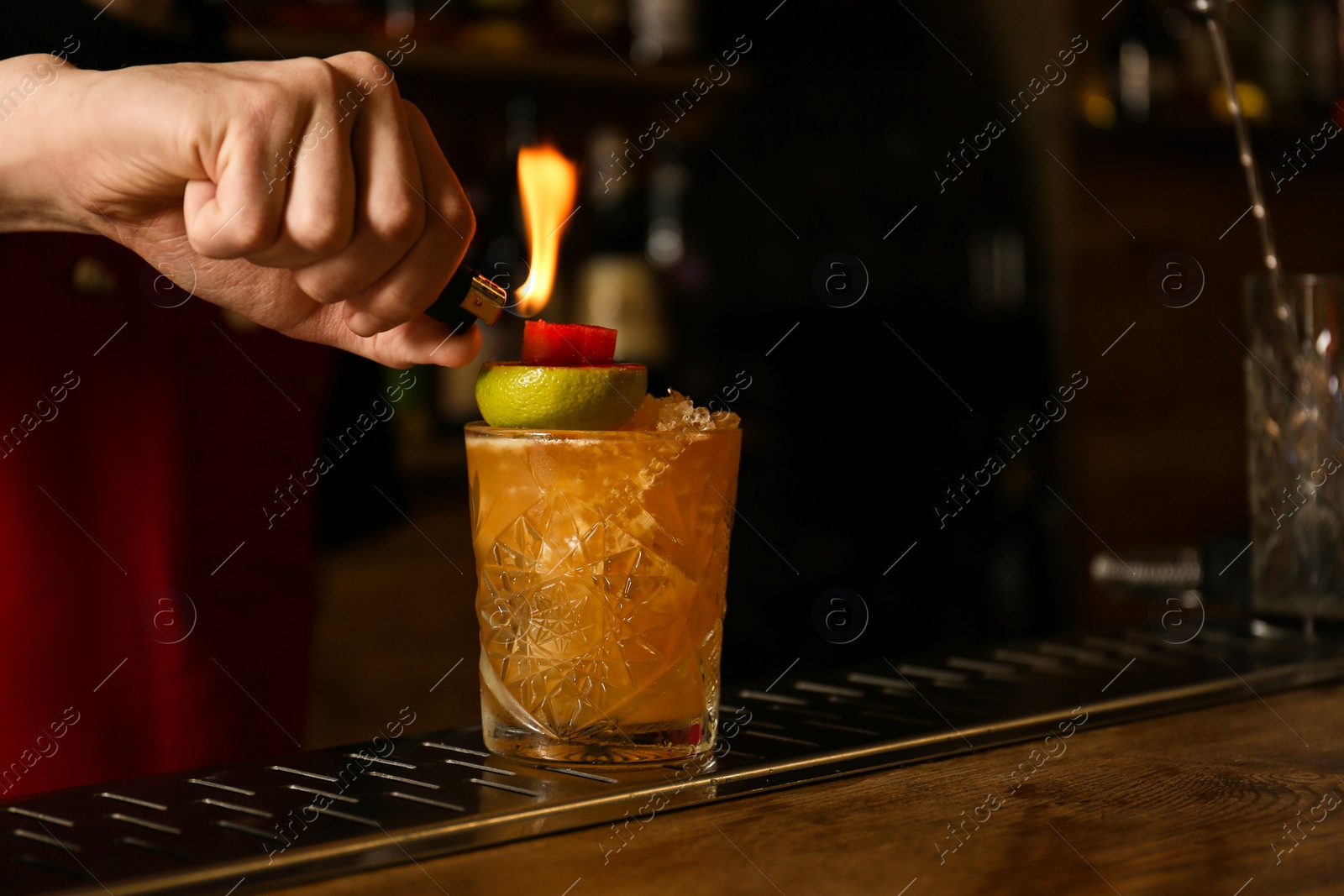 Photo of Bartender preparing fresh alcoholic cocktail at bar counter, closeup