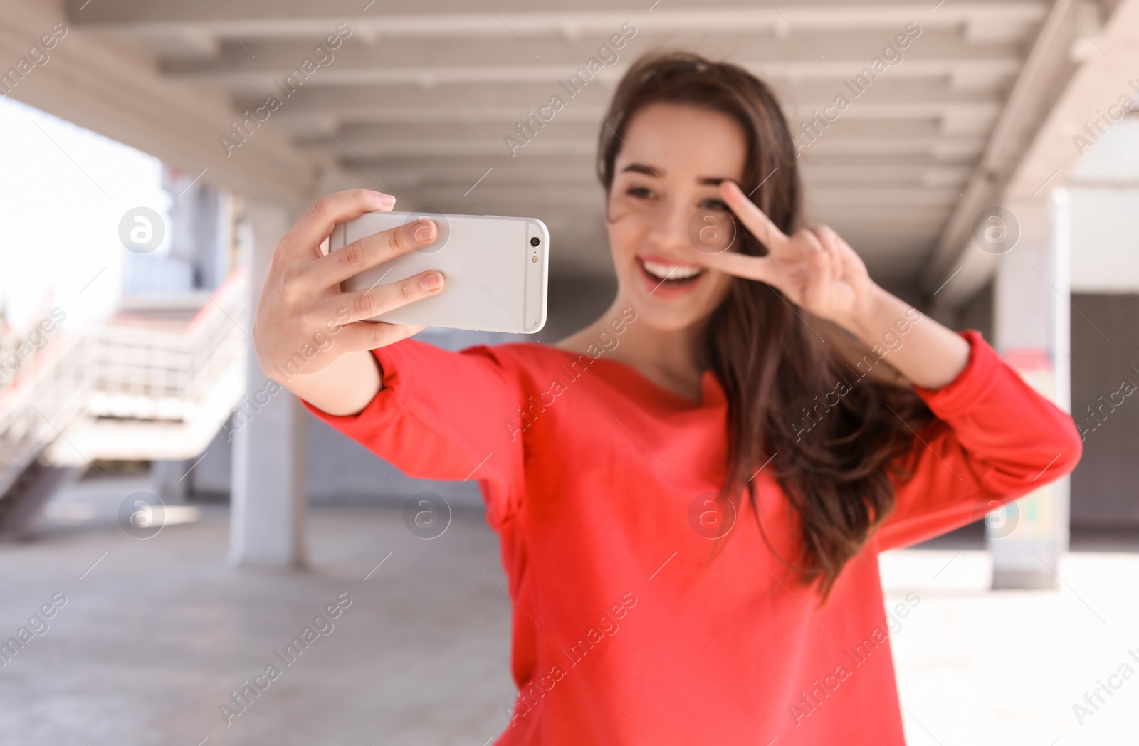 Photo of Attractive young woman taking selfie with phone outdoors