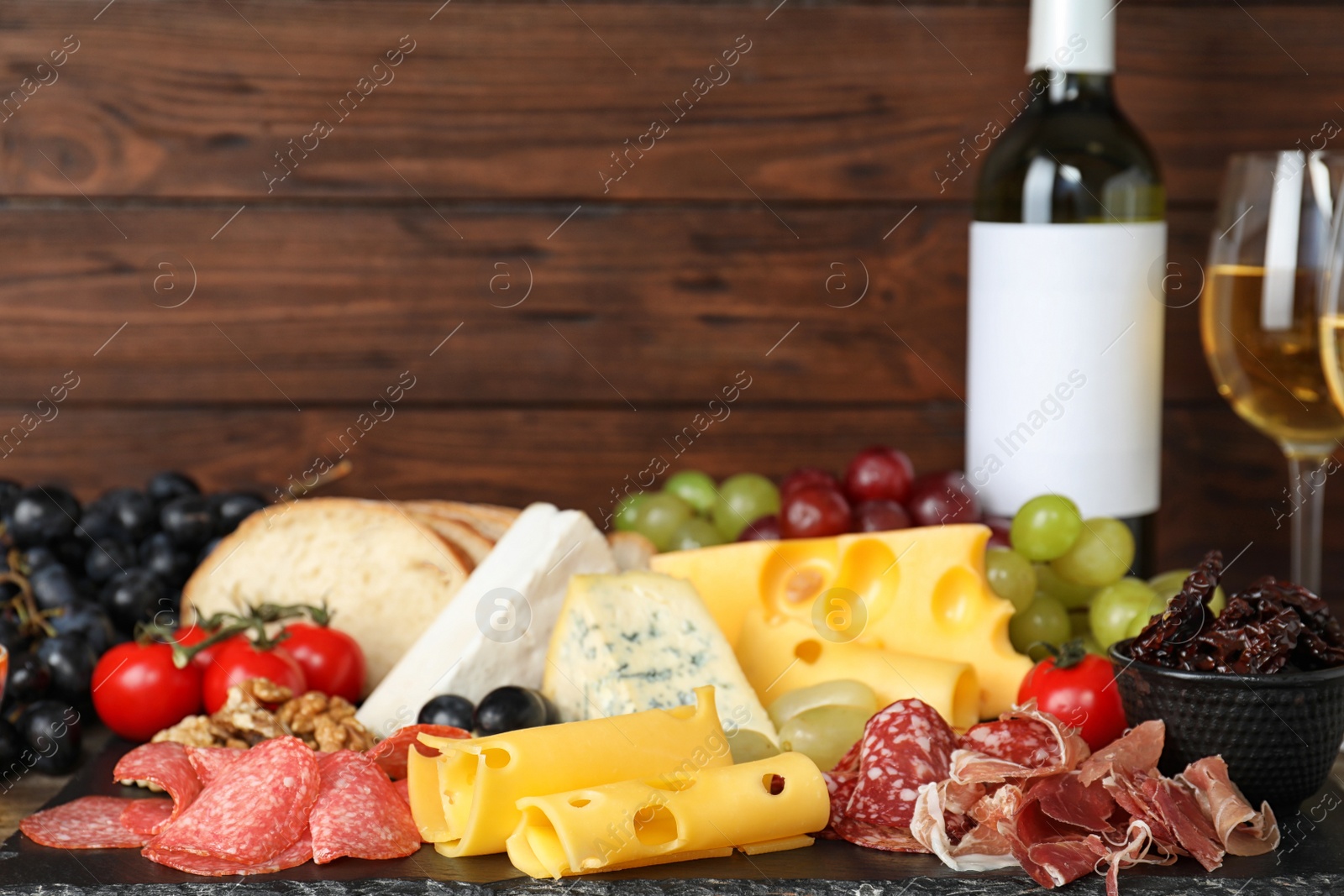 Photo of Composition with wine and snacks on table. Space for text