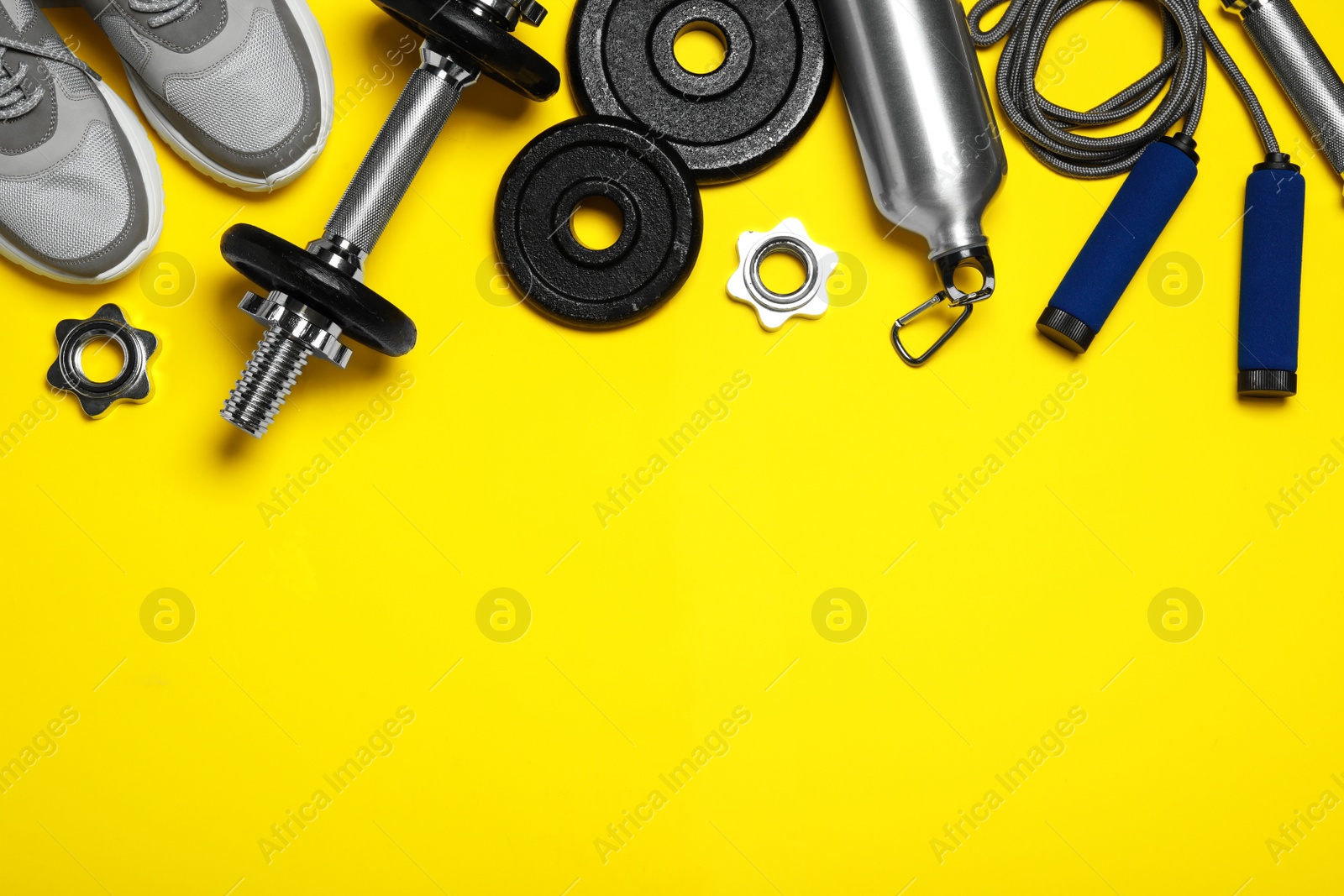Gym equipment on yellow background, flat lay. Space for text Photo of Gym equipment on yellow background, flat lay. Space for text