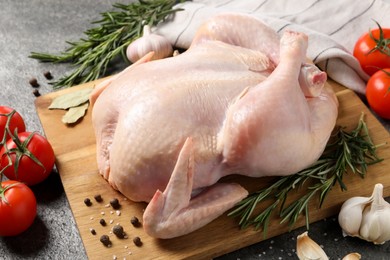 Photo of Fresh raw chicken with spices and vegetables on grey table