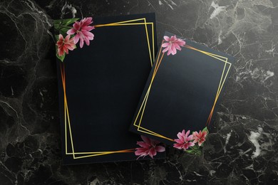Photo of Blank invitation cards on black marble background, top view. Space for text