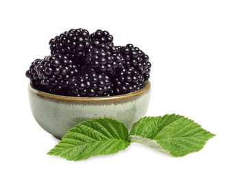 Bowl of ripe blackberries and green leaves isolated on white