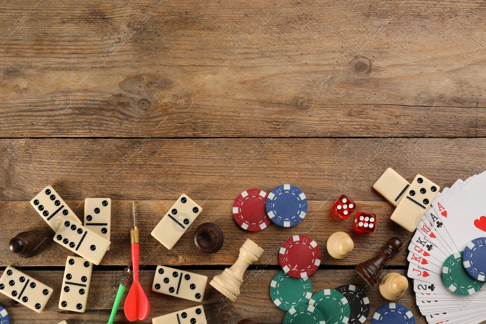 Photo of Elements of different board games on wooden table, flat lay. Space for text