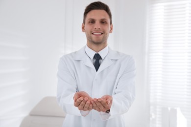 Photo of Dentist holding something in clinic, focus on hands