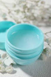 Lip balm and gypsophila on white background, closeup