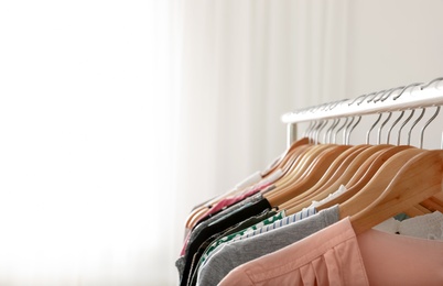 Photo of Wardrobe rack with stylish clothes indoors, closeup. Space for text