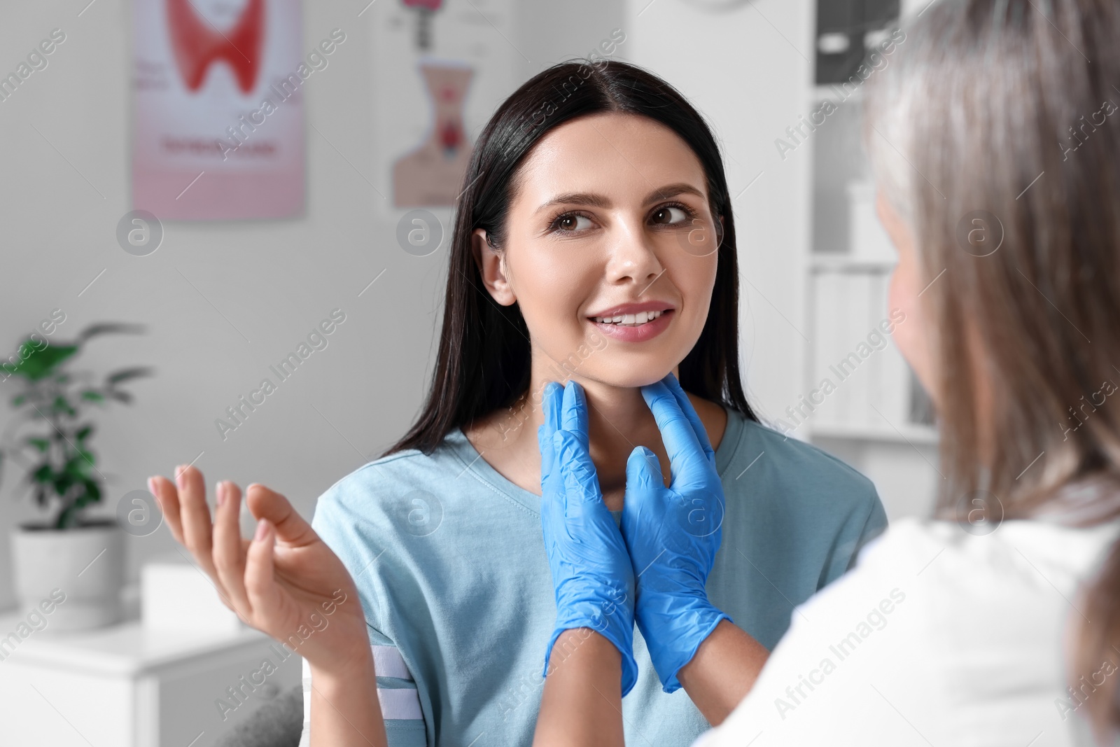 Photo of Endocrinologist examining thyroid gland of patient at hospital