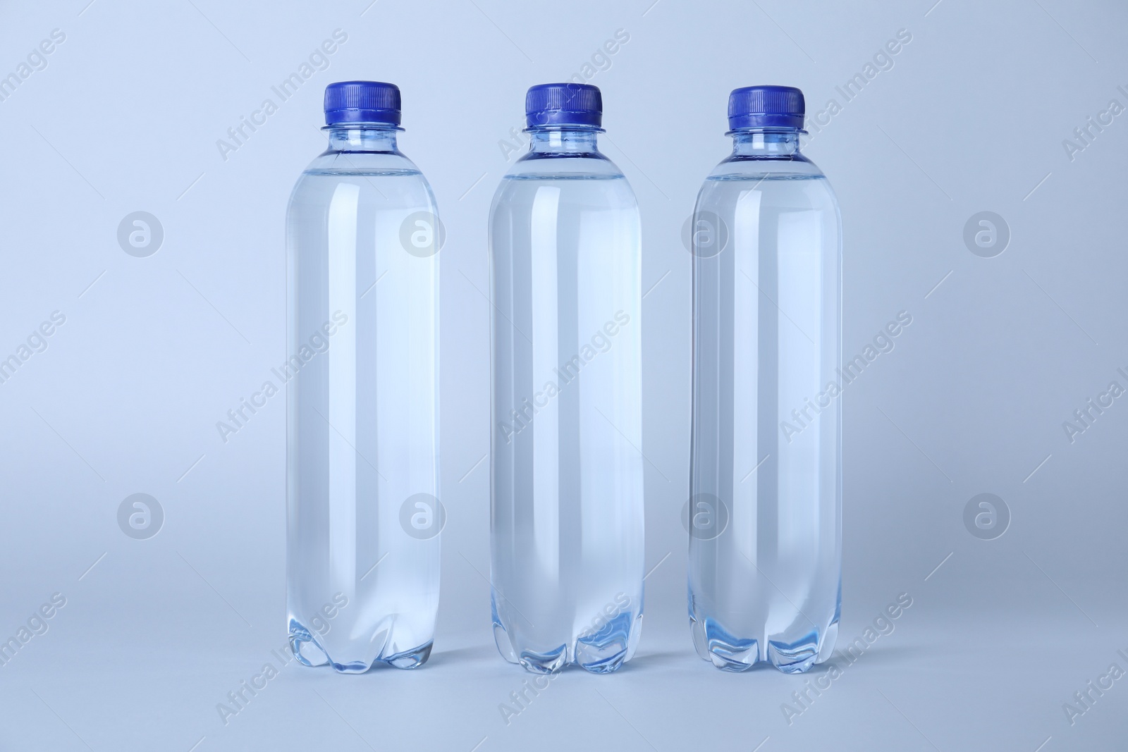 Photo of Plastic bottles with water on white background