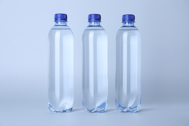 Photo of Plastic bottles with water on white background