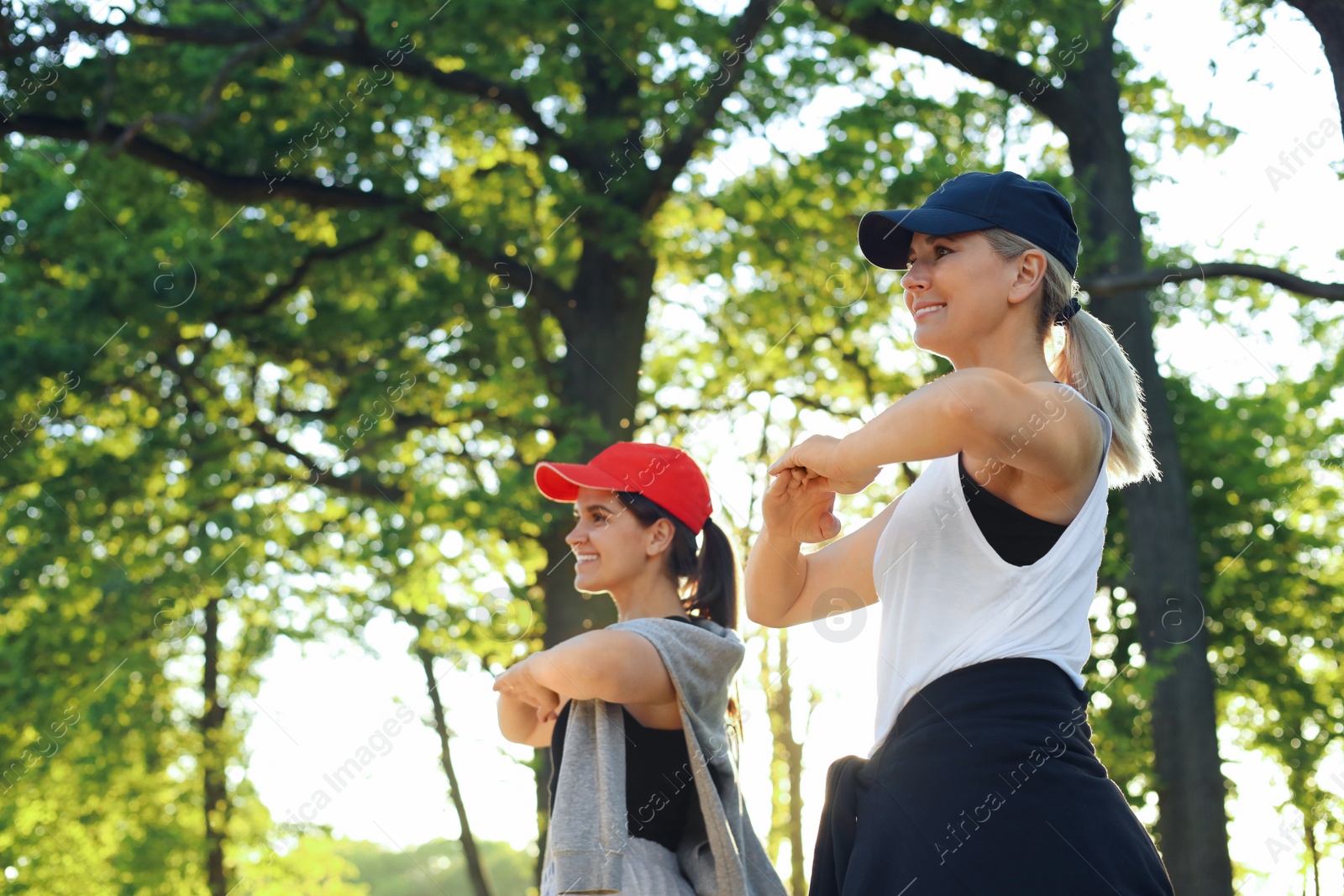 Photo of Women doing morning exercise in park. Space for text