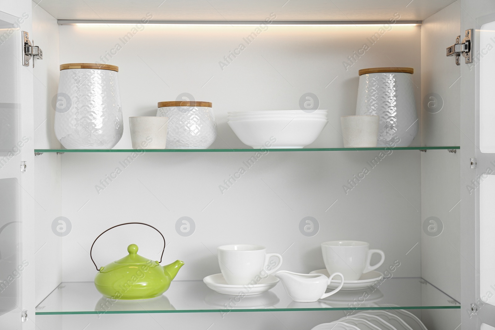 Photo of Open kitchen cabinet with different clean dishware