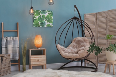 Photo of Elegant living room interior with hanging armchair and fuzzy rug