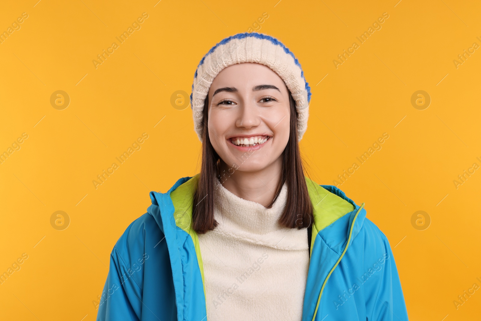 Photo of Portrait of beautiful woman smiling on orange background