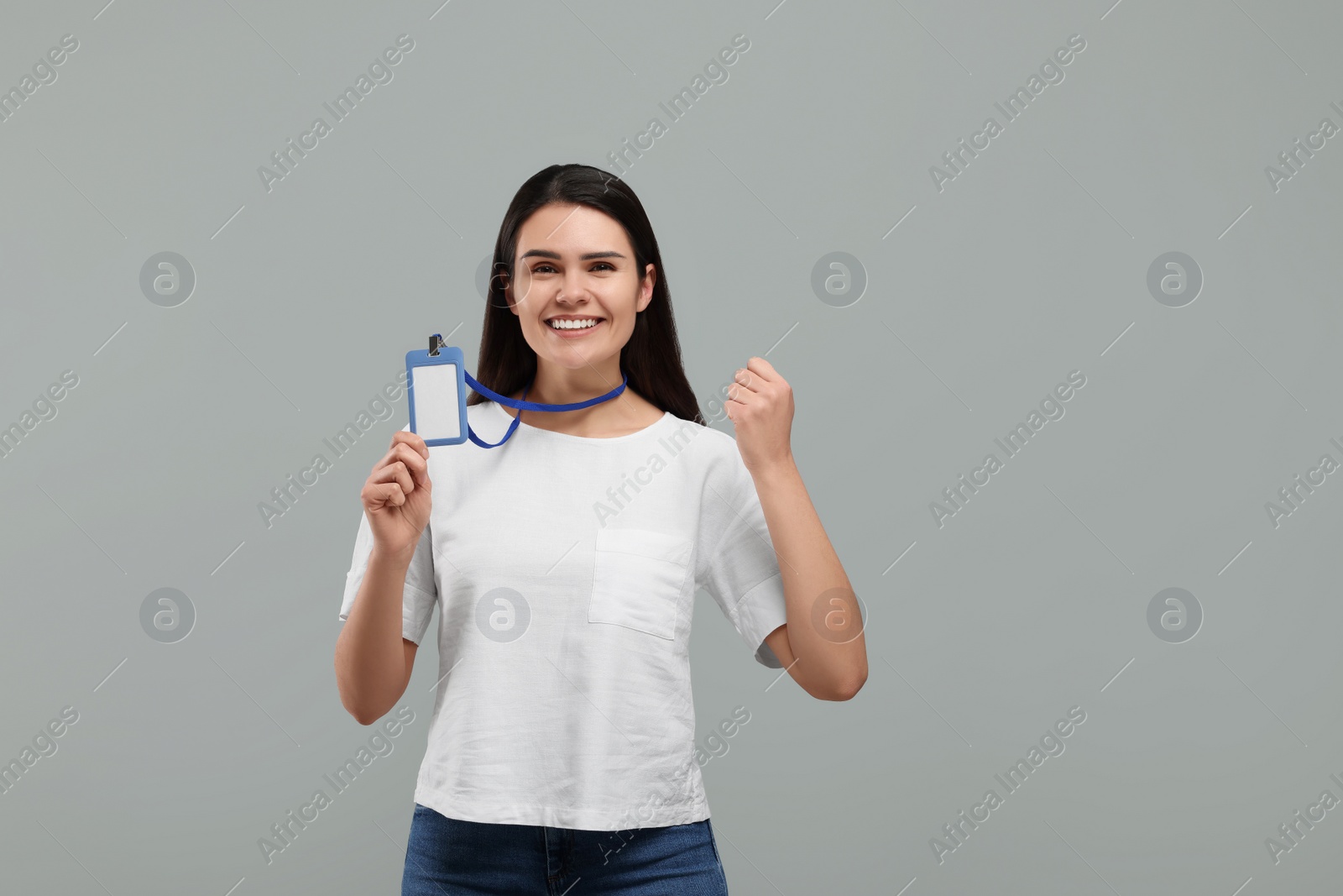 Photo of Emotional woman holding vip pass badge on grey background. Space for text