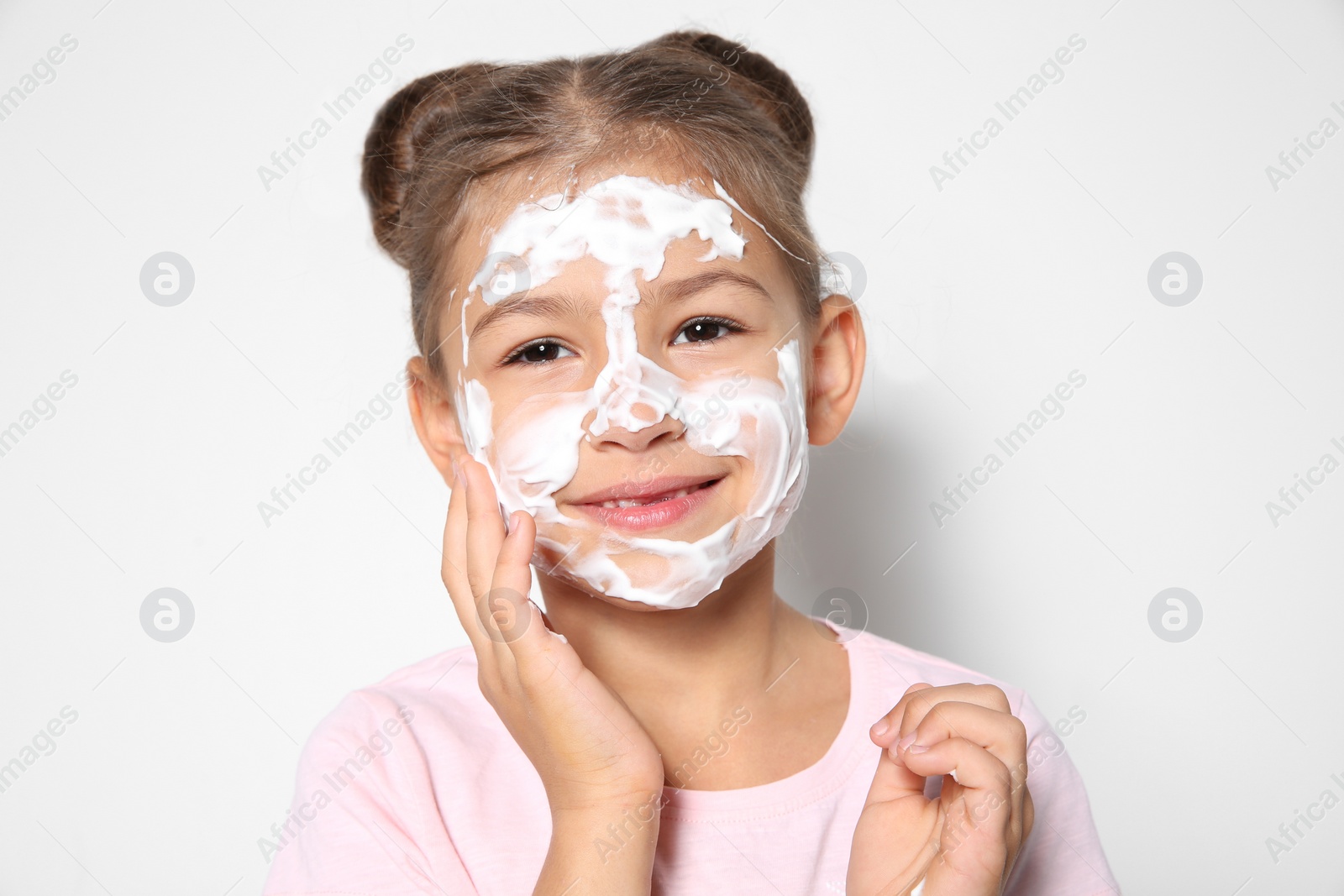 Photo of Cute little girl with soap foam on face against white background