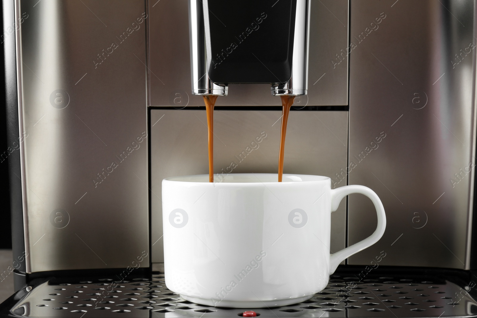 Photo of Modern espresso machine pouring coffee into cup, closeup