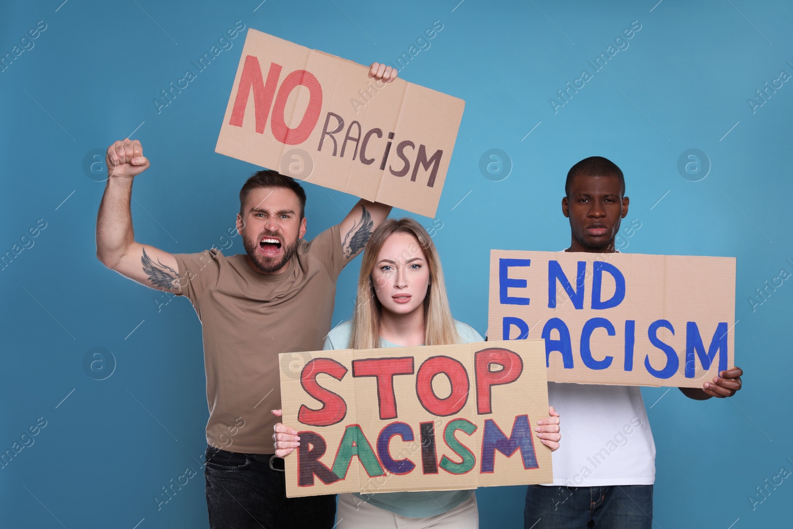 Photo of Protesters demonstrating different anti racism slogans on light blue background. People holding signs with phrases