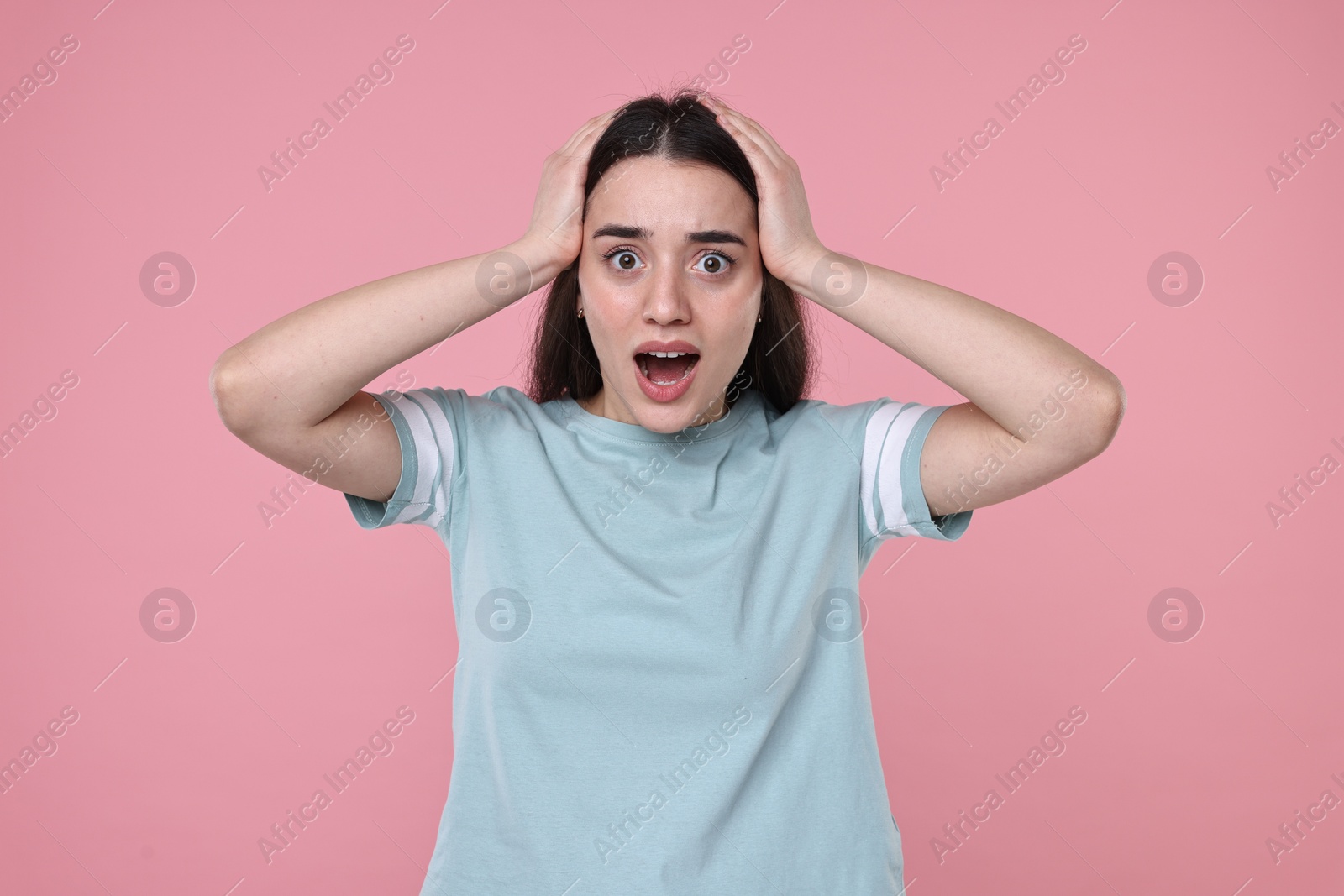 Photo of Portrait of surprised woman on pink background