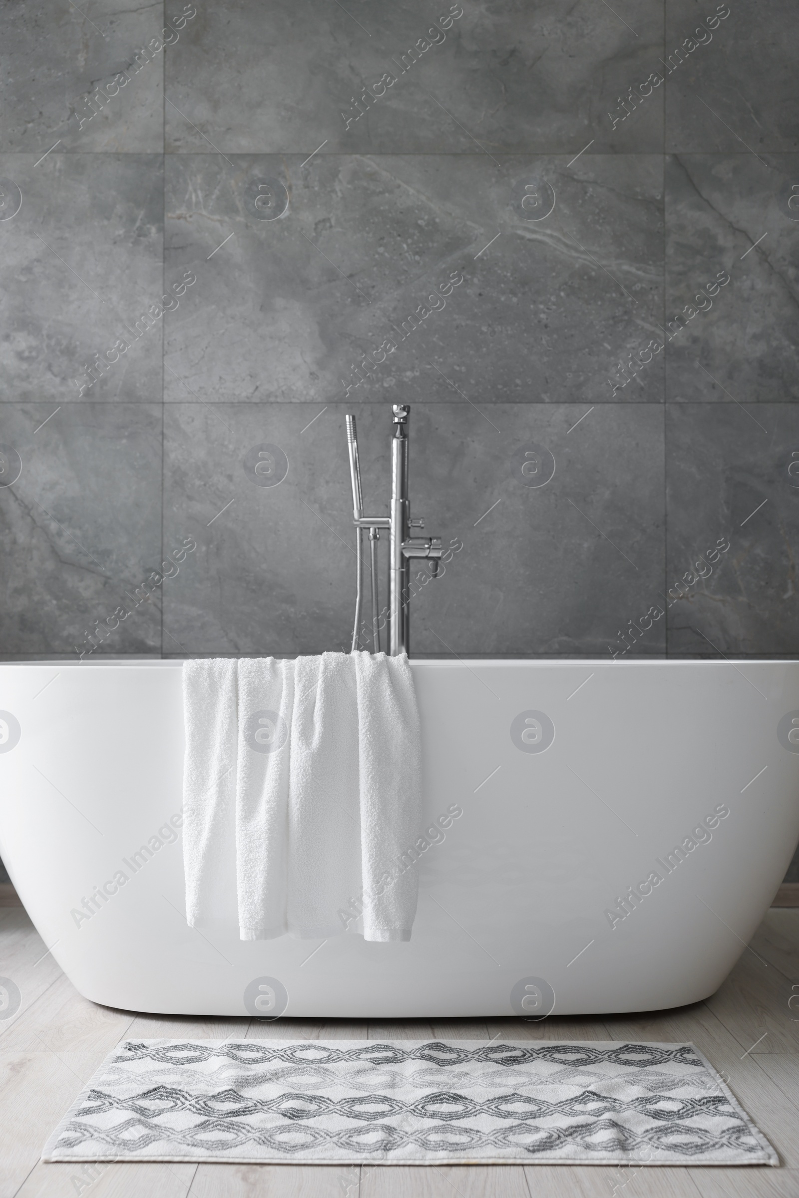 Photo of Fresh white towels on tub in bathroom