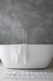 Photo of Fresh white towels on tub in bathroom