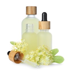 Photo of Bottles of essential oil and linden flowers on white background