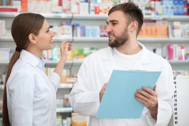 Professional pharmacists working together in modern drugstore