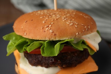 Tasty cheeseburger with patties on plate, closeup